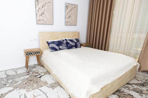 a bedroom with a large bed with blue pillows at Garden View Apartment in Rrushkull