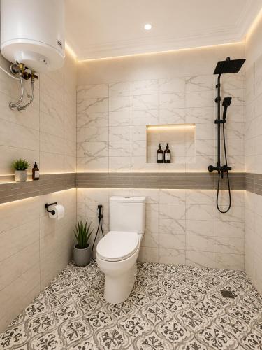 a bathroom with a toilet and a tiled floor at The Blue Resort in Yaoundé