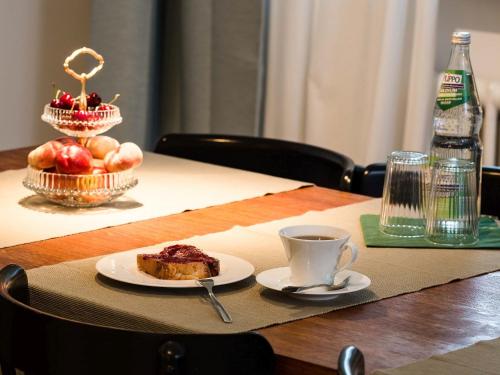 a table with a plate of food and a cup of coffee at Apartment Am Apfelbaum in Reutlingen
