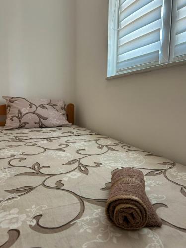 a bedroom with a bed with a blanket on it at Apartman Šarenac in Bileća