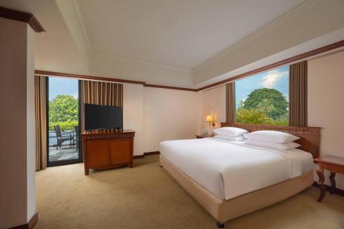 a hotel room with a bed and a television at Hyatt Regency Yogyakarta in Yogyakarta
