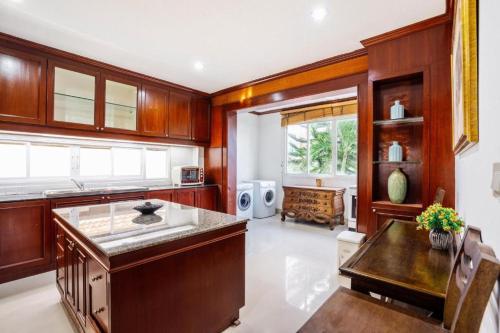 a large kitchen with wooden cabinets and a table at The Phuket Pool Villa in Phuket
