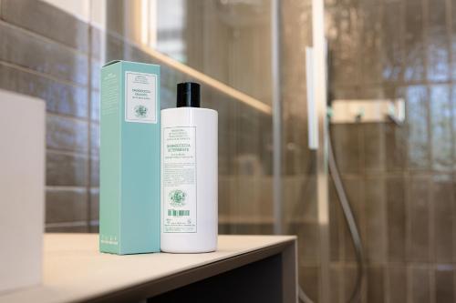 a bottle of shampoo sitting on a table next to a shower at Residence Da Marco in Pieve di Soligo