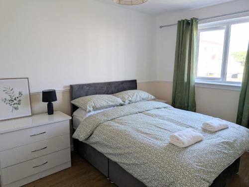 a bedroom with a bed with two towels on it at Mach House in Campbeltown