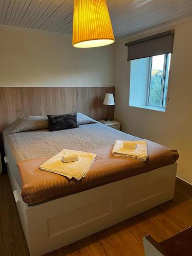 a bedroom with a bed with two towels on it at Vale Das 7Lagoas in Geres