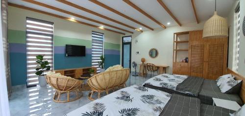 a bedroom with a bed and a table and chairs at Bee House in Long Thủy