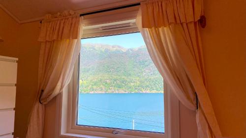 a window with a view of a lake and mountains at Markhus Apartment Near Langfoss in Markhus