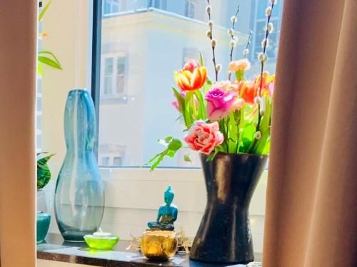 a window sill with a vase with flowers in it at De Lotuspoort met Mihr's rustplek in de Abdij van Bornem in Bornem