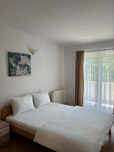 a bedroom with a white bed and a window at Family rest apartments in Nikšić