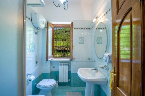 a bathroom with a sink and a toilet and a window at Il Vigneto in Tramonti