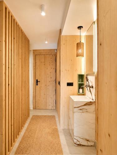 a bathroom with a sink and a wooden door at Viviendas El Tiburón in Almerimar