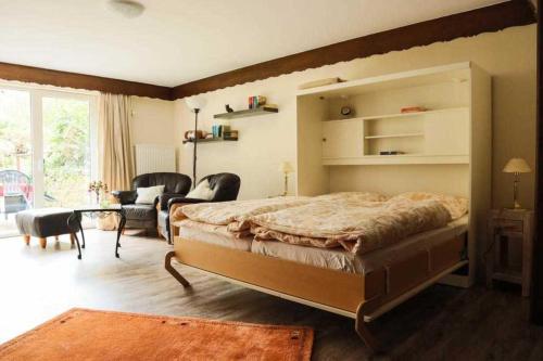 a bedroom with a large bed and a living room at Feriendomizil Bockelmann in Bad Bevensen