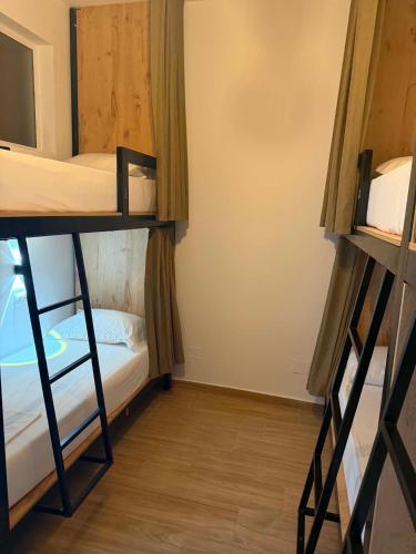 a room with two bunk beds and a wooden floor at Bume's Hostel in Sarandë