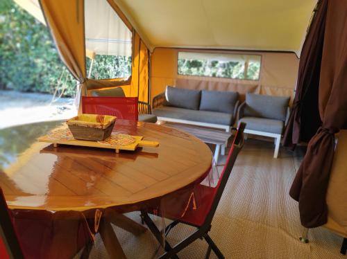 a dining table and a couch in a tiny house at clos du loguy in Pénestin