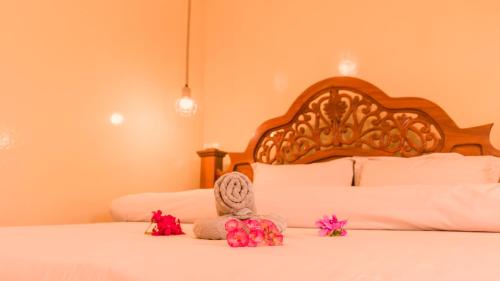 a bedroom with a white bed with a wooden headboard at Kendwa Stay in Kendwa