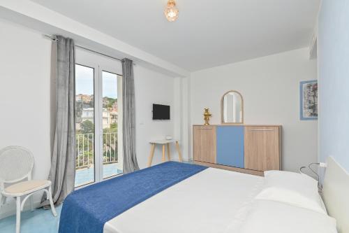 a white bedroom with a large bed and a window at Agropoli Palace in Agropoli