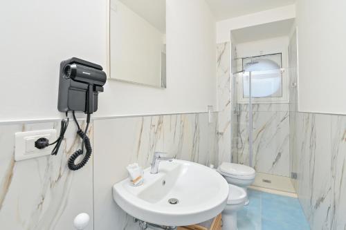 a bathroom with a sink and a phone on the wall at Agropoli Palace in Agropoli