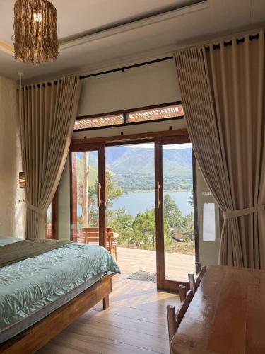 a bedroom with a bed and a large glass door at Slash Villa in Silimapuluh