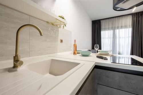 a white kitchen with a sink and a window at White Pampas Tiny Houses 1 in Paralia Dionysiou
