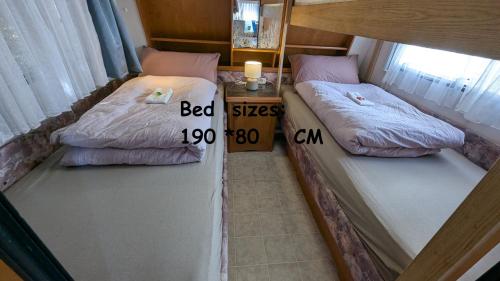 two beds in a room with a price sign between them at Mikael's Bed & Spa - Camping Suite in Sandefjord