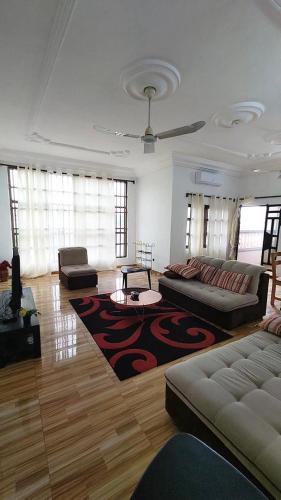 a living room with couches and a rug at Home Appart in Porto-Novo