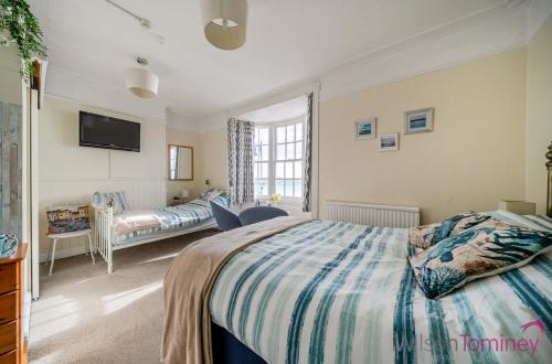 a bedroom with a bed and a tv on the wall at Lyndale Guest House in Weymouth