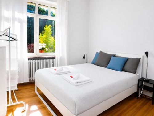 a white bed in a white room with a window at rooms lux city in Luxembourg