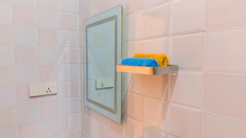 a bathroom with a mirror and a shelf with a towel at Kendwa Stay in Kendwa