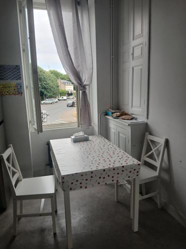 a table and two chairs in a room with a window at Riverside house in Issoudun