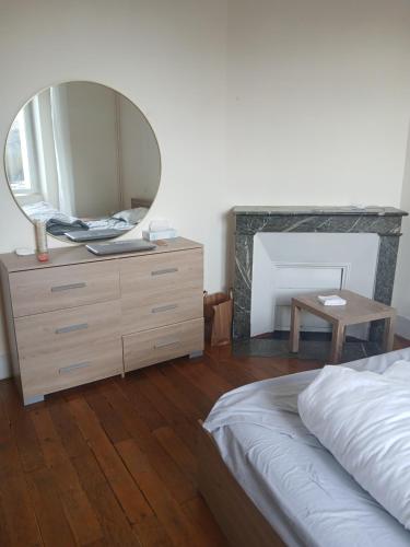 a bedroom with a dresser with a mirror on it at Riverside house in Issoudun