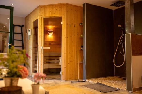 a room with a shower with a wooden wall at HolzHaus AusZeit am Küppel & Bright Collection in Gersfeld