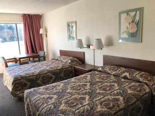 a hotel room with two beds and a table at Flagship Inn in Petersburg