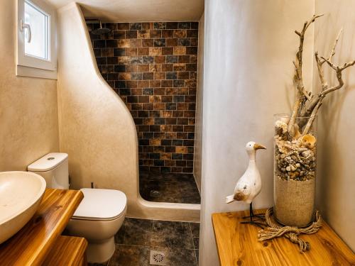 a bathroom with a toilet and a duck on a wooden table at Navis Luxury in Skala Kallirachis