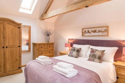a bedroom with a large bed with towels on it at The Haughmond in Upton Magna