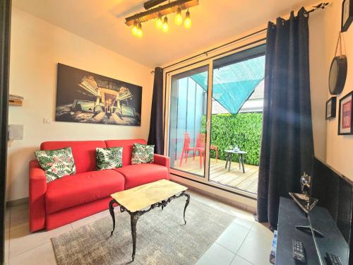 a living room with a red couch and a window at Indus, Confort en centre-ville in Vannes