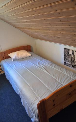 a bed in a room with a wooden ceiling at Sundqvistens basement in Emkarby