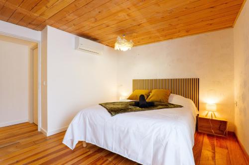 a bedroom with a bed with a cat sitting on it at Maison de Charme - Écrin de Nature in Saint-Privat