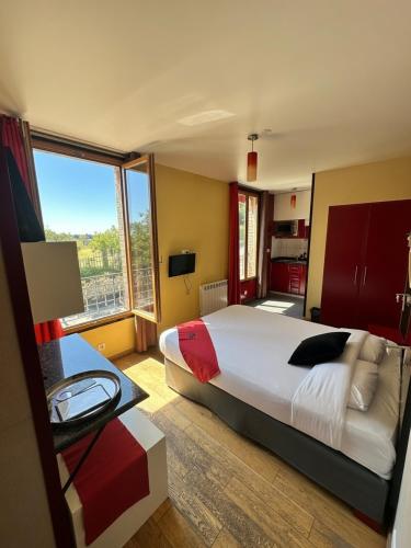 ein Schlafzimmer mit einem großen Bett und einem großen Fenster in der Unterkunft Marinha Hôtel in Gentilly