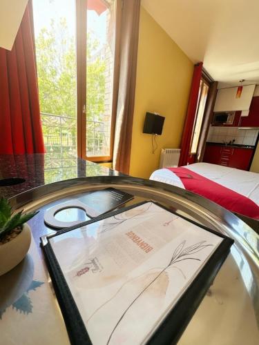 ein Zimmer mit einem Tisch, einem Fenster und einem Bett in der Unterkunft Marinha Hôtel in Gentilly