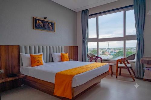 a bedroom with a large bed and a large window at Hotel 5 Elements By Fidato Hotels in Akalkot