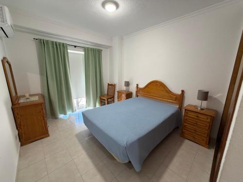 a bedroom with a blue bed and a window at Casa Nau C in Armação de Pêra