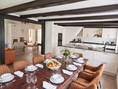 a dining room with a table and a kitchen at FH Luhe-Hof - Historisches Reetdachanwesen in Winsen