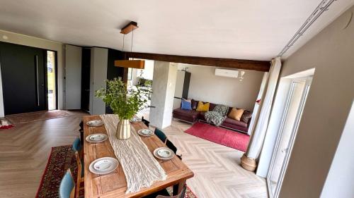 a dining room with a wooden table and a couch at Kõpu Seaside Getaway in Rannaküla