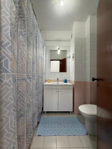 a bathroom with a shower with a sink and a toilet at Casa Nau C in Armação de Pêra