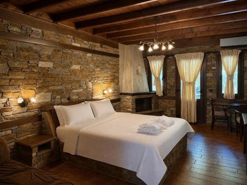 a bedroom with a large bed in a brick wall at Thermes Pozar Resort in Kato Loutraki