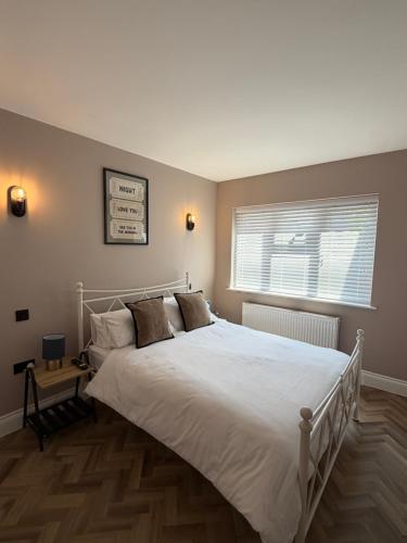 a bedroom with a large white bed and a window at Entire Flat in Lichfield City Centre in Lichfield