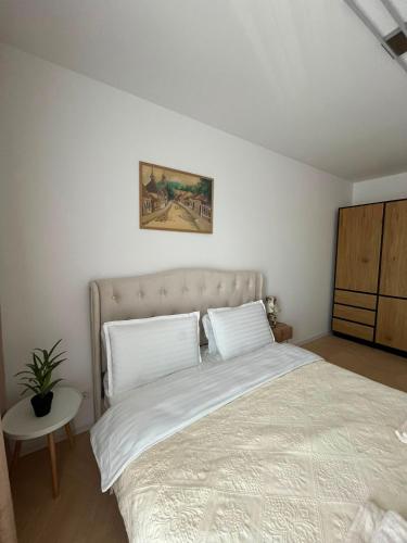 a bedroom with a large bed with white sheets at Luna Residence in Baia Mare