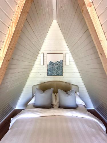 a bed with two pillows in a triangular room at Serenity in Eşelniţa