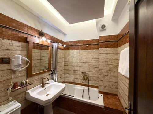a bathroom with a sink and a bath tub at Thermes Pozar Resort in Kato Loutraki