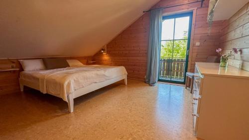a bedroom with a bed and a large window at HolzHaus AusZeit am Küppel & Bright Collection in Gersfeld